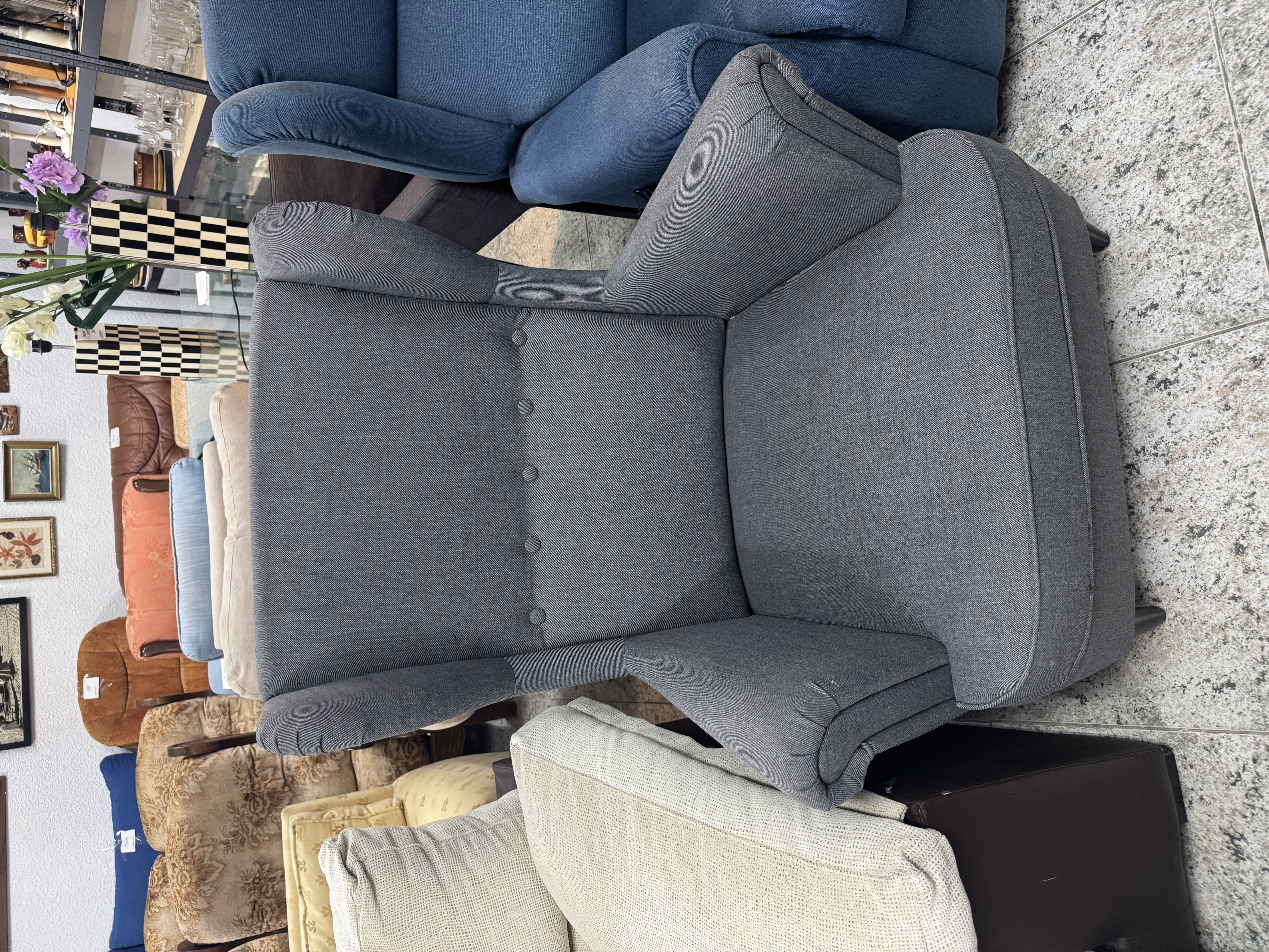 Sillón tapizado gris con botones decorativos