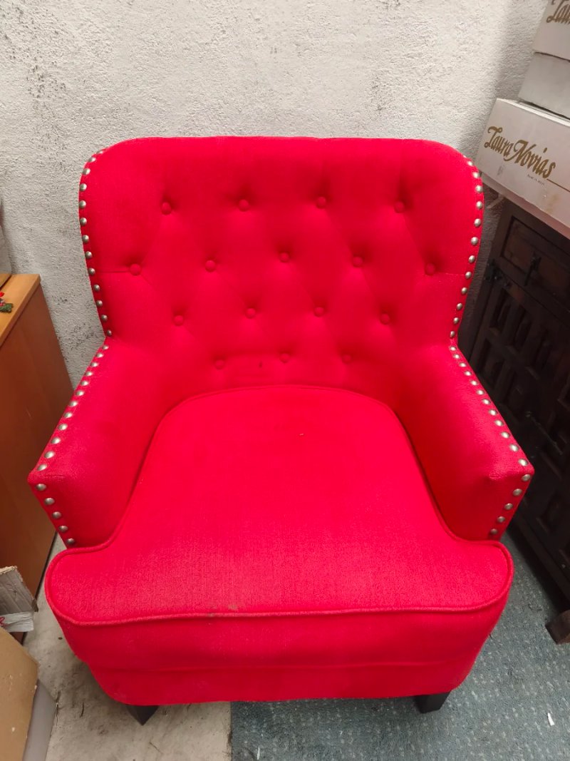Sillón orejero clásico con tapizado capitoné en rojo