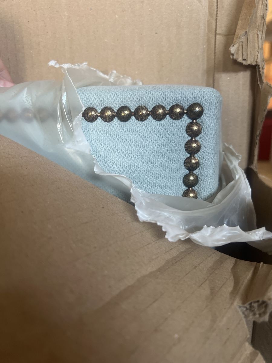 Cabecero tapizado azul claro con tachuelas decorativas
