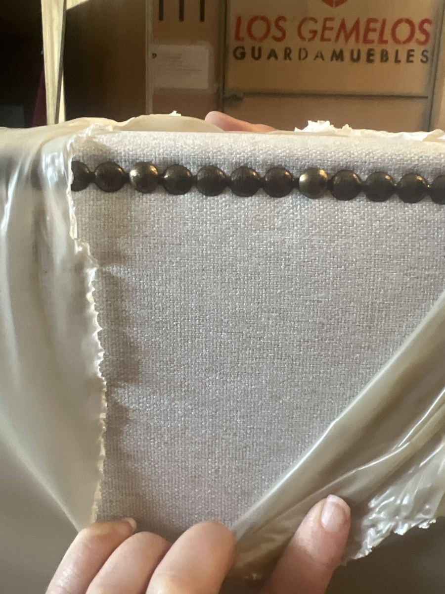 Cabecero tapizado beige con tachuelas decorativas
